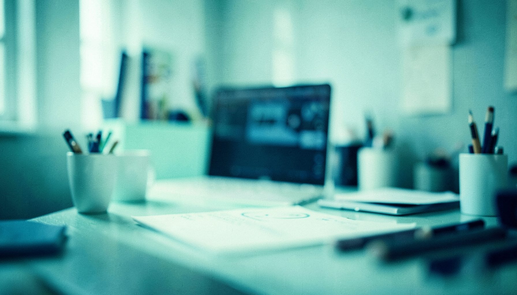 A small soft-focus image in pale mint and navy colors showing an abstract calm workspace mood
